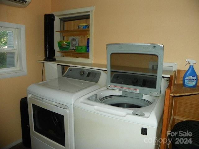 laundry room with an AC wall unit and separate washer and dryer