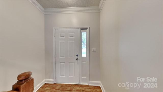 foyer with hardwood / wood-style floors, a textured ceiling, and ornamental molding