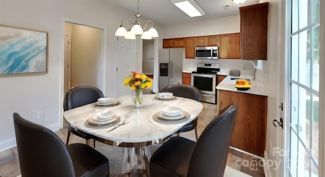 dining space featuring a chandelier and sink