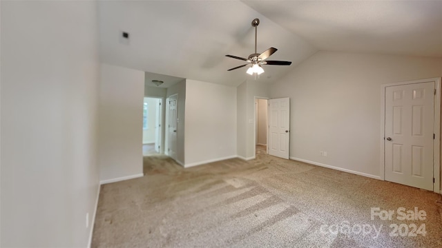 unfurnished bedroom with ceiling fan, light colored carpet, and vaulted ceiling