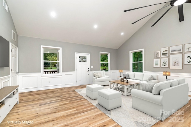 living area with ceiling fan, light wood finished floors, visible vents, and a healthy amount of sunlight