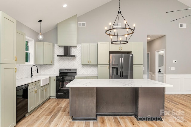 kitchen with black appliances, wall chimney exhaust hood, a sink, and visible vents