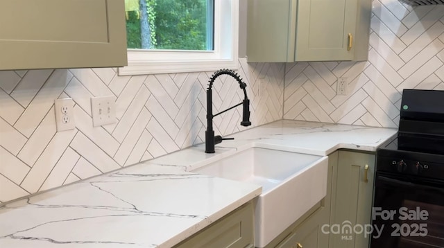 kitchen featuring tasteful backsplash, a sink, light stone countertops, and black electric range oven