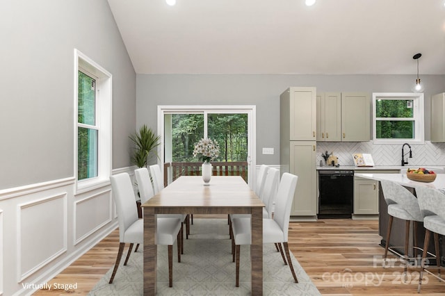 dining room featuring a healthy amount of sunlight, light wood-type flooring, and wainscoting