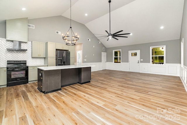 kitchen featuring visible vents, stainless steel fridge with ice dispenser, wall chimney exhaust hood, light countertops, and black range oven