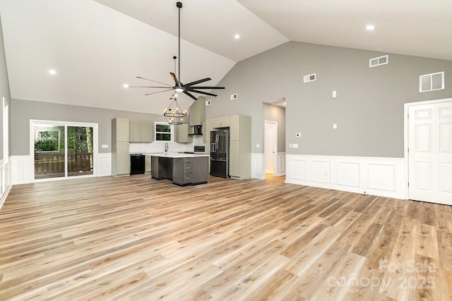 unfurnished living room featuring light wood-style floors, visible vents, and an inviting chandelier