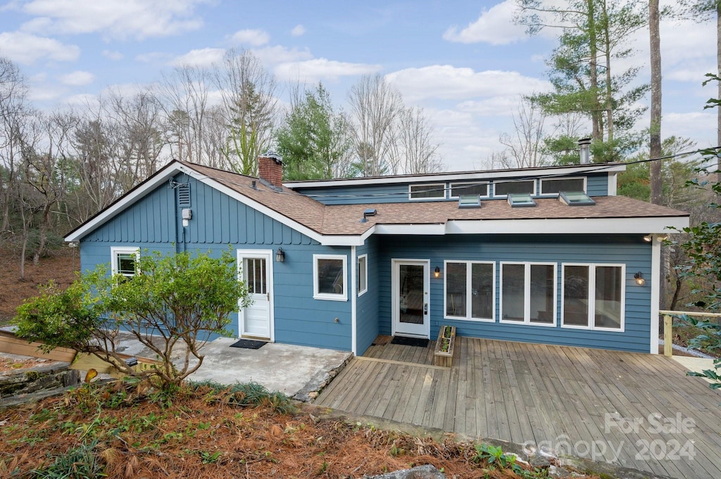 rear view of property featuring a deck