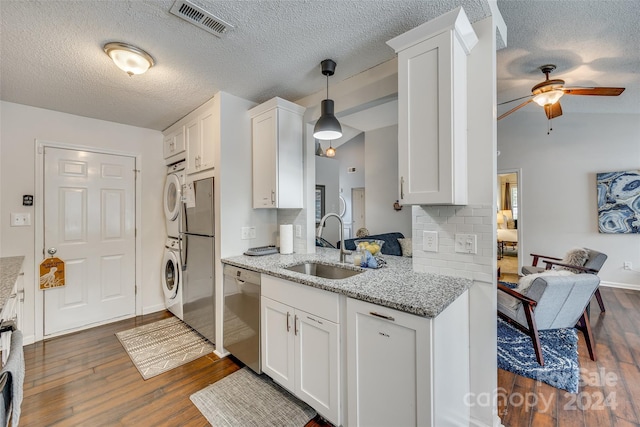 kitchen with white cabinetry, stacked washer and clothes dryer, dark hardwood / wood-style flooring, hanging light fixtures, and appliances with stainless steel finishes