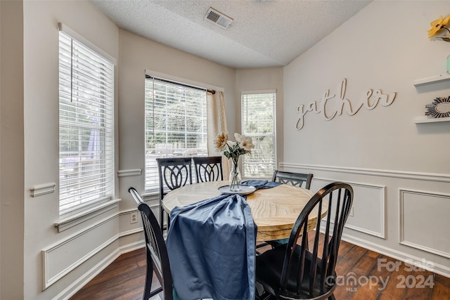 dining space featuring dark hardwood / wood-style flooring and a textured ceiling