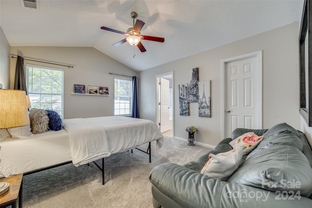 carpeted bedroom featuring multiple windows, lofted ceiling, ceiling fan, and a textured ceiling