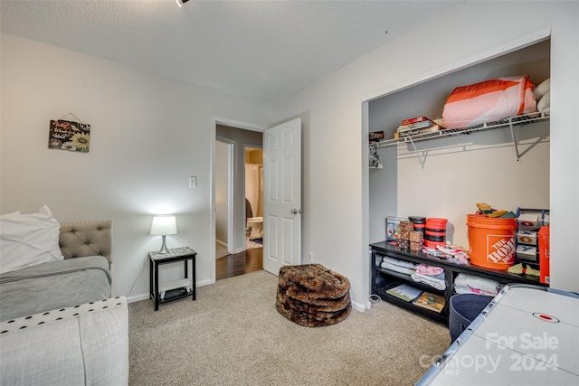 carpeted bedroom featuring a closet and a textured ceiling