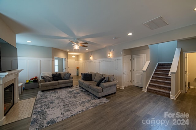 living room with ceiling fan and dark wood-type flooring