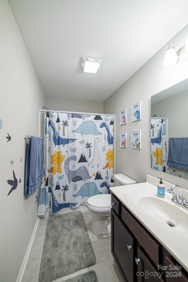 bathroom with tile patterned flooring, vanity, a shower with shower curtain, and toilet