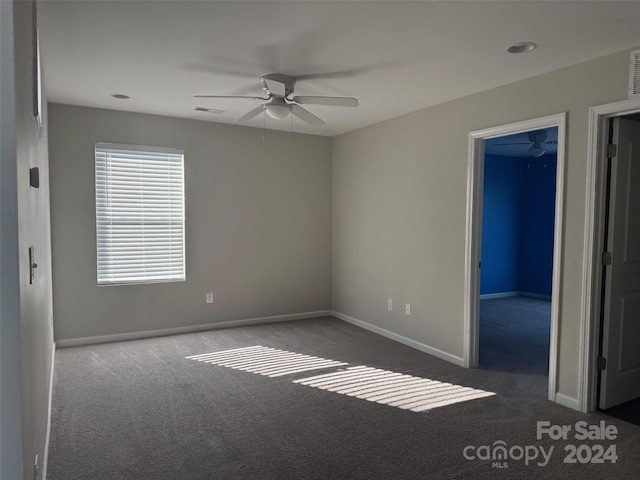 carpeted spare room with ceiling fan