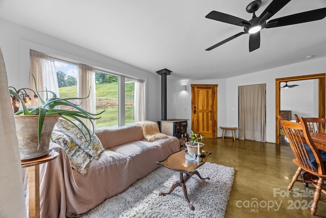 44 Brookside Dr, Burnsville, NC 28714 - living area featuring finished concrete floors, a wood stove, and a ceiling fan