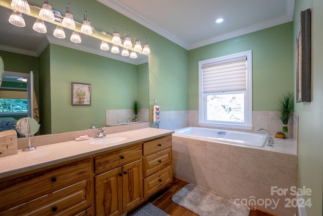 bathroom with ornamental molding, vanity, hardwood / wood-style floors, and tiled bath