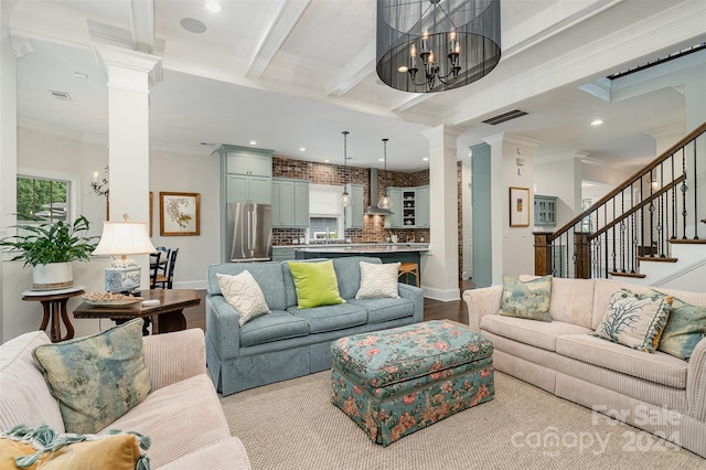 living room featuring light wood-type flooring, an inviting chandelier, and crown molding