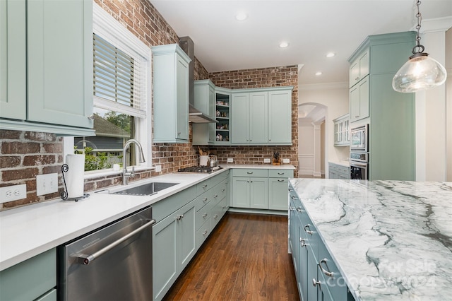 kitchen with decorative light fixtures, appliances with stainless steel finishes, sink, dark wood-type flooring, and ornamental molding