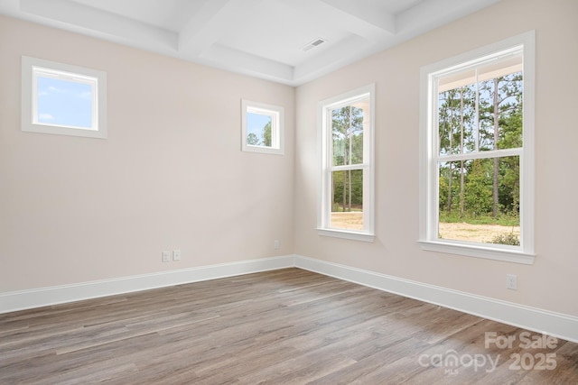 spare room featuring coffered ceiling, beam ceiling, and light hardwood / wood-style flooring