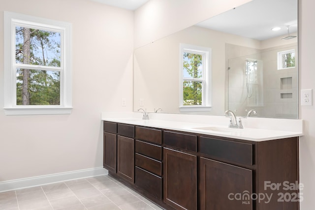 bathroom featuring vanity, a shower with shower door, and a wealth of natural light