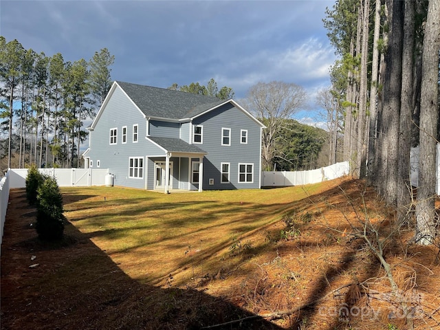 rear view of property featuring a lawn