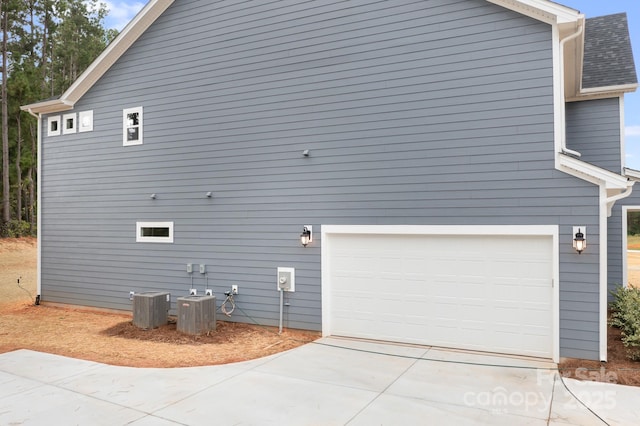 view of home's exterior with a garage and central AC unit