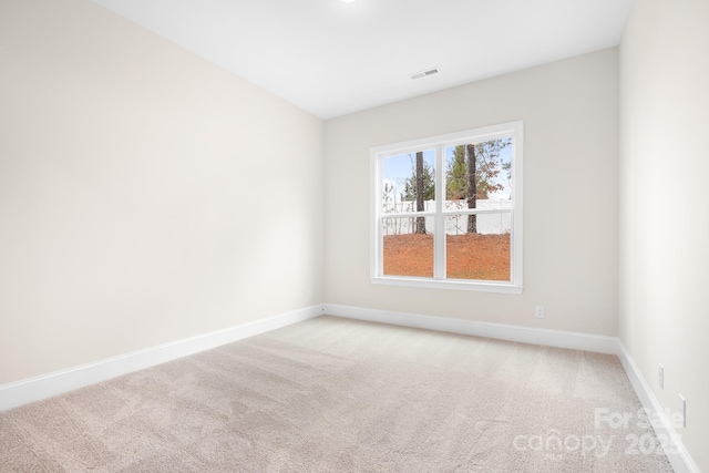 unfurnished room featuring light carpet