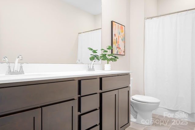 bathroom with tile patterned flooring, vanity, and toilet