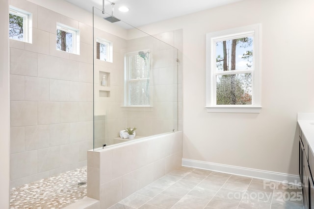 bathroom with vanity and tiled shower