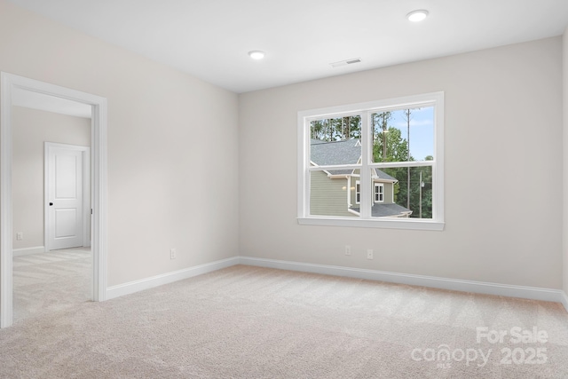 spare room featuring light colored carpet