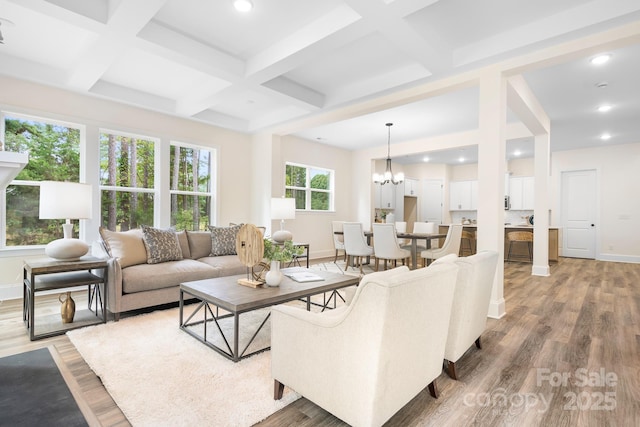 living room with a chandelier, wood-type flooring, coffered ceiling, and beam ceiling