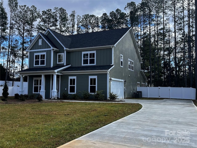 craftsman-style house featuring central AC unit, a garage, and a front yard