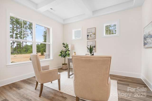 sitting room featuring beamed ceiling, wood-type flooring, and coffered ceiling