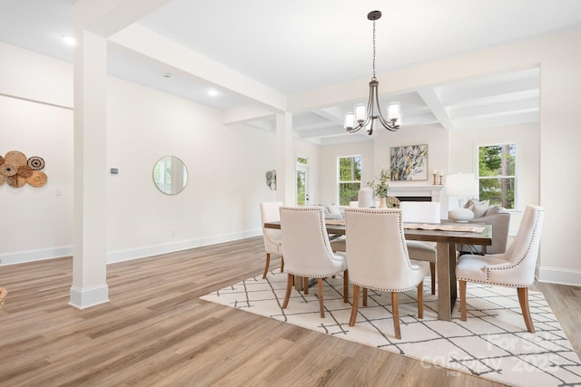 dining room featuring beamed ceiling, plenty of natural light, light hardwood / wood-style floors, and coffered ceiling