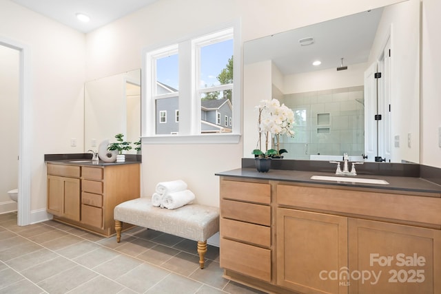 bathroom featuring tile patterned floors, vanity, toilet, and a shower with shower door