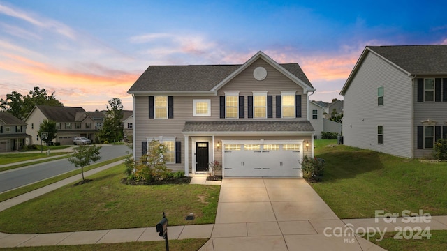 view of front property with a garage and a lawn