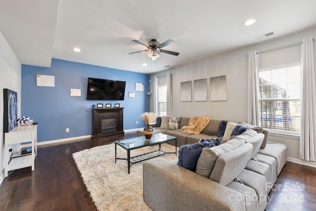 living room featuring dark wood-type flooring and ceiling fan