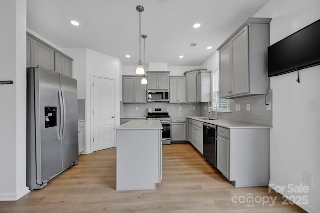 kitchen with gray cabinets, a kitchen island, and stainless steel appliances