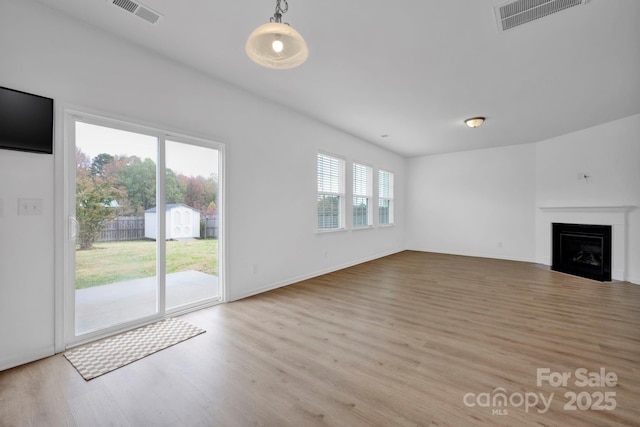 unfurnished living room with light hardwood / wood-style flooring and a wealth of natural light