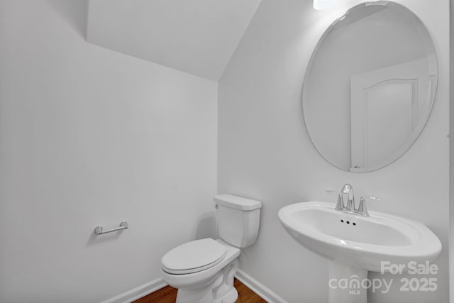 bathroom featuring hardwood / wood-style floors, toilet, and lofted ceiling