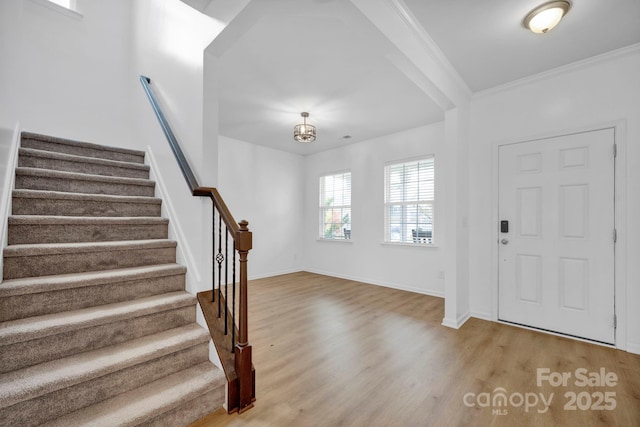 entryway featuring wood-type flooring and ornamental molding