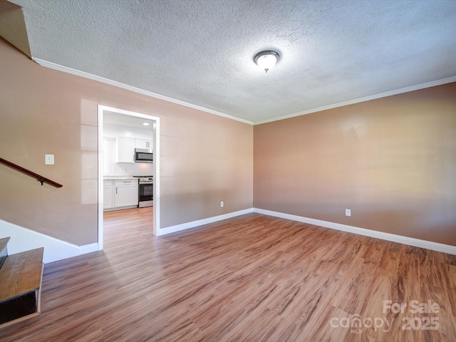 unfurnished room with a textured ceiling, light hardwood / wood-style flooring, and crown molding