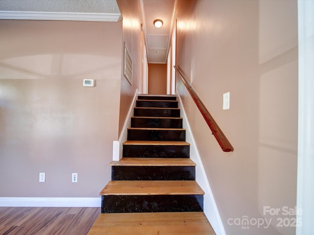 stairway featuring wood-type flooring and ornamental molding