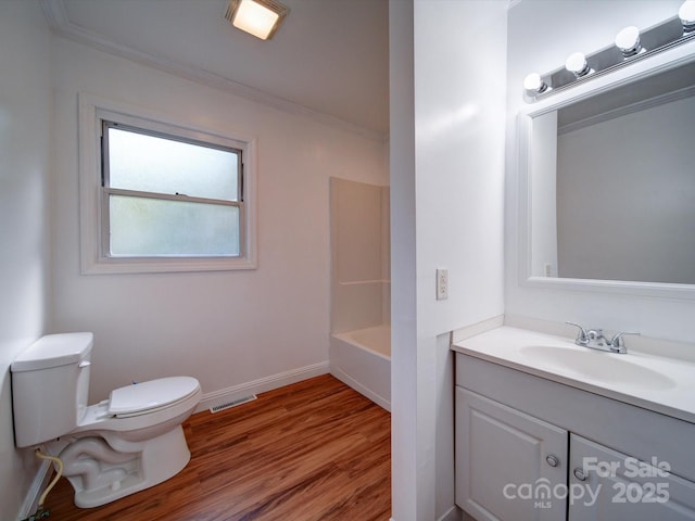 full bathroom featuring tub / shower combination, crown molding, toilet, vanity, and hardwood / wood-style flooring