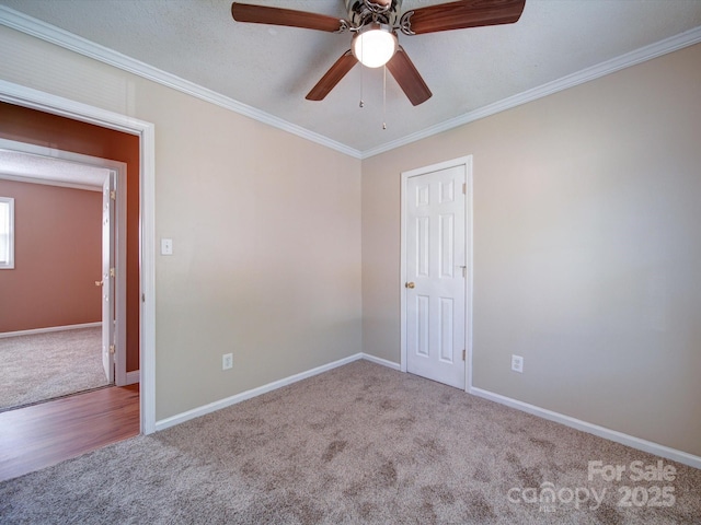 carpeted empty room featuring a textured ceiling, ceiling fan, and crown molding