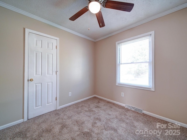 carpeted empty room with ceiling fan, a textured ceiling, and ornamental molding