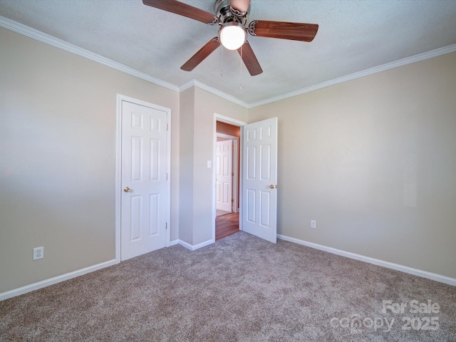 unfurnished bedroom with ceiling fan, carpet floors, a textured ceiling, and ornamental molding