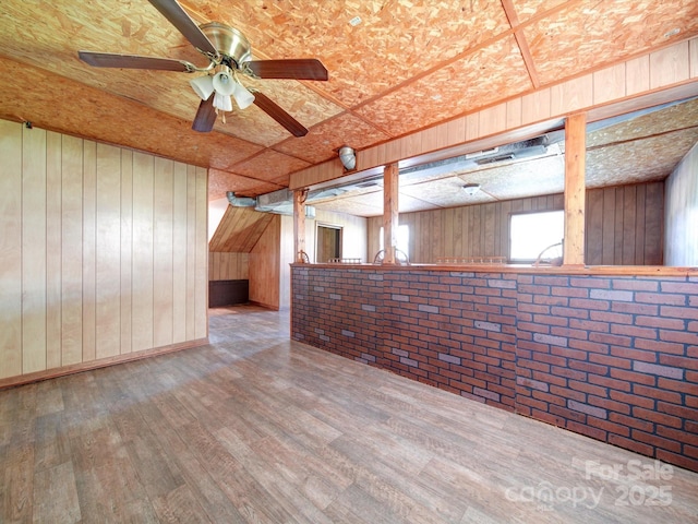 spare room featuring brick wall and hardwood / wood-style flooring