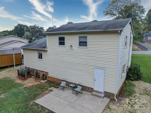 back of property featuring a lawn, a patio area, and central AC