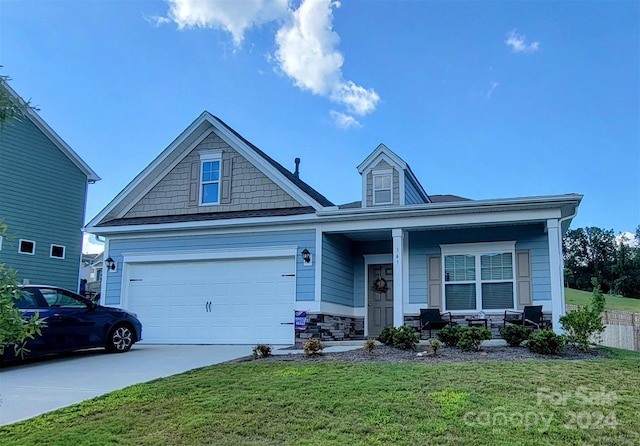 view of front of house featuring a porch, a garage, and a front yard